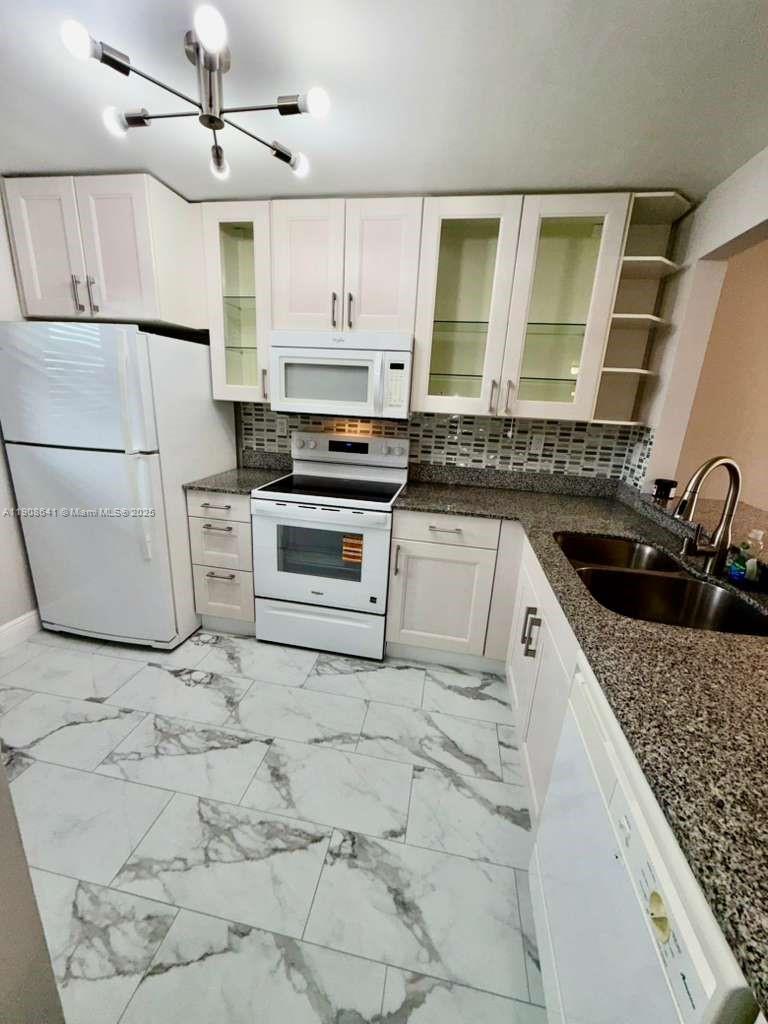 10288 Northwest 9th St Circle, Unit 307 Miami, FL 33172 - Photo 12 of 14 a kitchen with stainless steel appliances granite countertop a sink stove and refrigerator