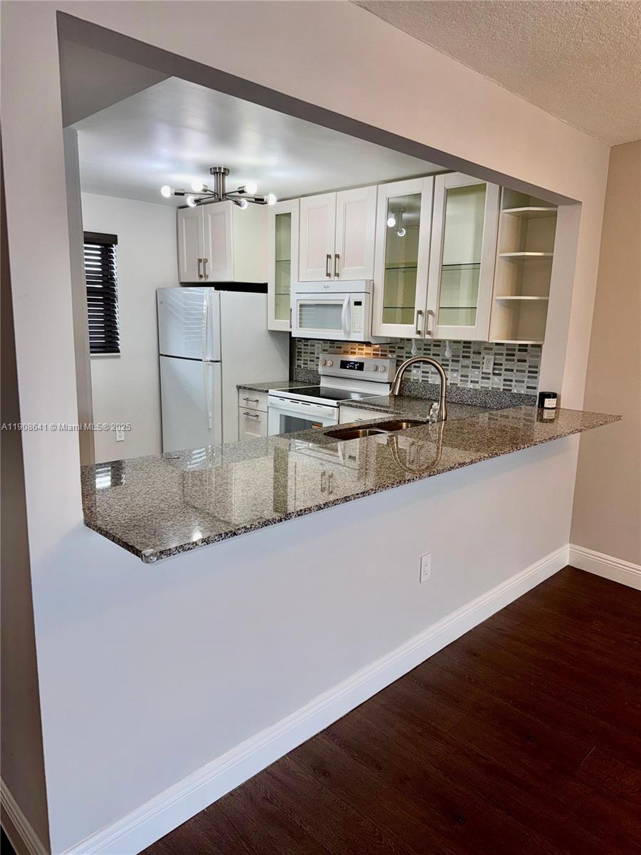 10288 Northwest 9th St Circle, Unit 307 Miami, FL 33172 - Photo 13 of 14 a kitchen with kitchen island a sink and refrigerator