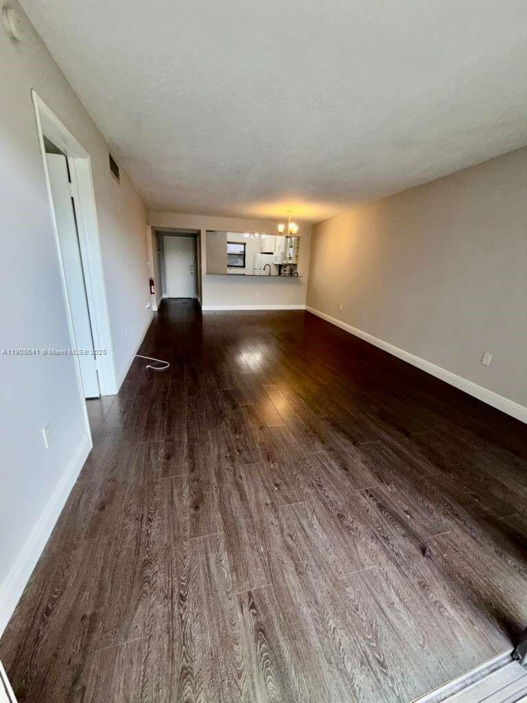 10288 Northwest 9th St Circle, Unit 307 Miami, FL 33172 - Photo 3 of 14 a view of an empty room with wooden floor and a window