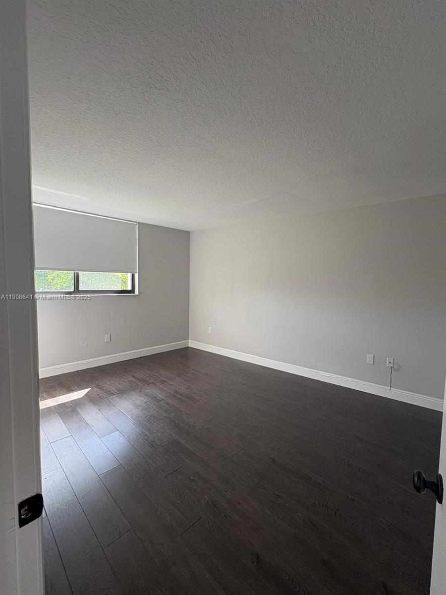 10288 Northwest 9th St Circle, Unit 307 Miami, FL 33172 - Photo 5 of 14 an empty room with wooden floor and windows