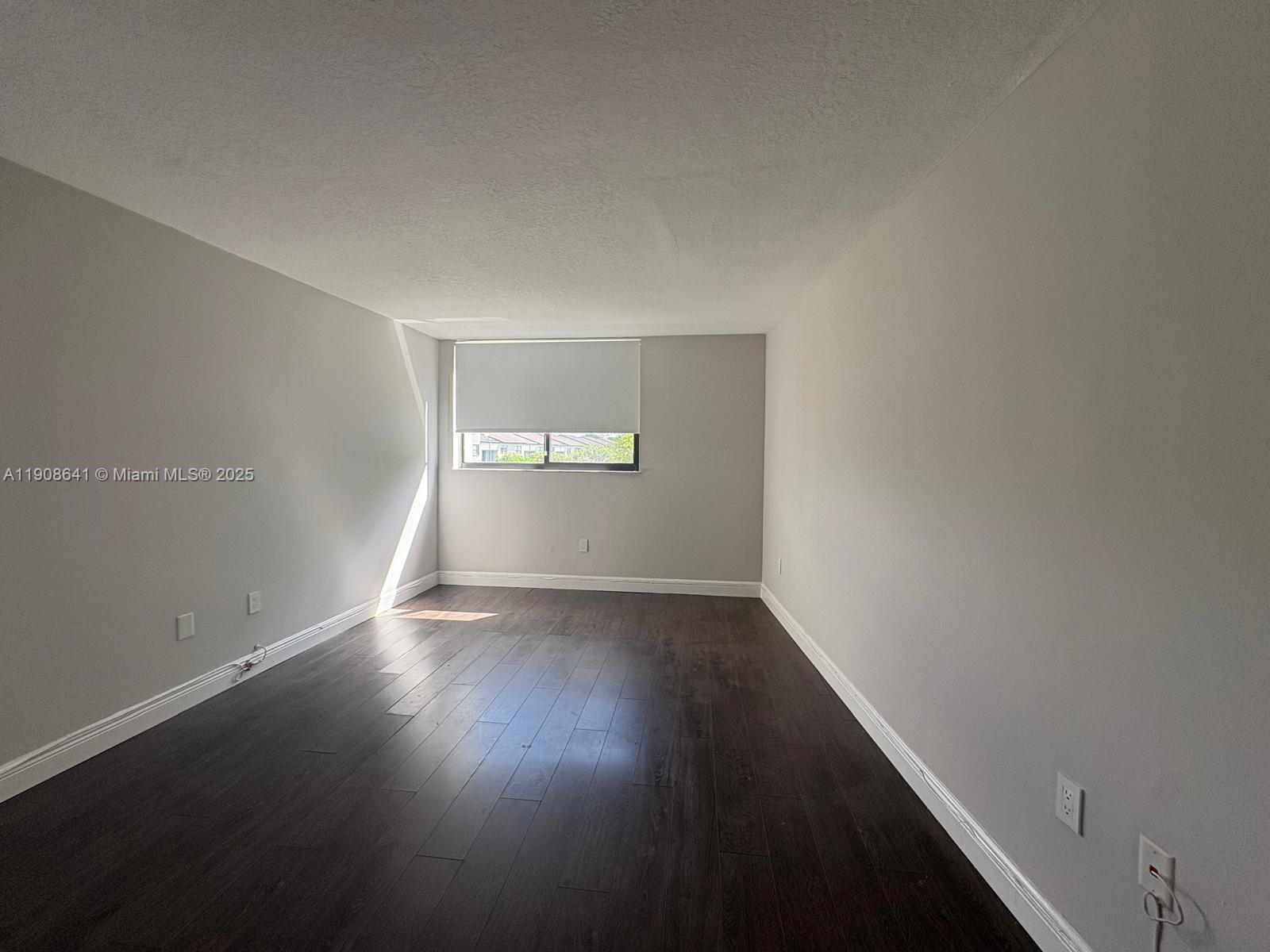 10288 Northwest 9th St Circle, Unit 307 Miami, FL 33172 - Photo 6 of 14 an empty room with wooden floor and windows