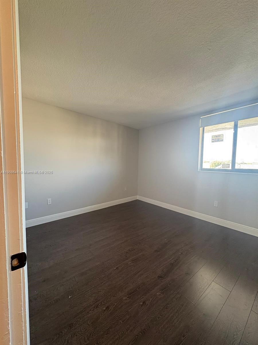 10288 Northwest 9th St Circle, Unit 307 Miami, FL 33172 - Photo 9 of 14 an empty room with wooden floor and windows