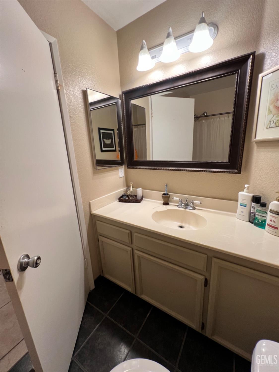 Undisclosed Address Bakersfield, CA 93307 - Photo 11 of 19 a bathroom with a double vanity sink and mirror