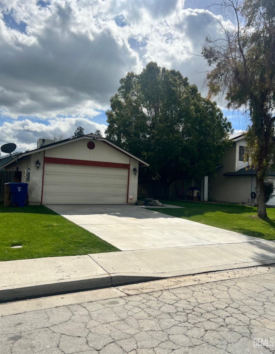 Undisclosed Address Bakersfield, CA 93307 - Photo 2 of 19 a front view of a house with a yard and a garage