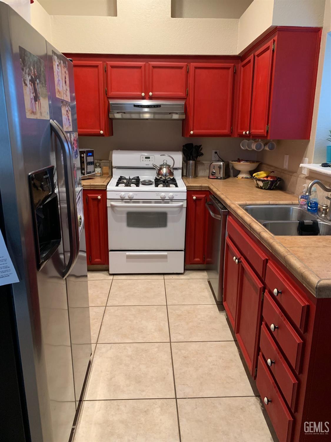 Undisclosed Address Bakersfield, CA 93307 - Photo 6 of 19 a kitchen with a stove a sink and a refrigerator