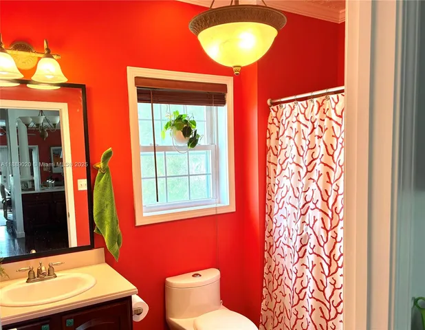 a bathroom with a sink mirror and a window
