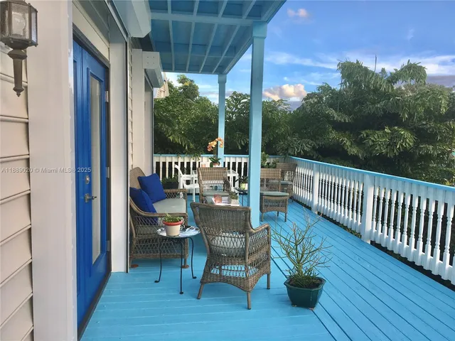 a view of a patio with couches chairs potted plants and city view