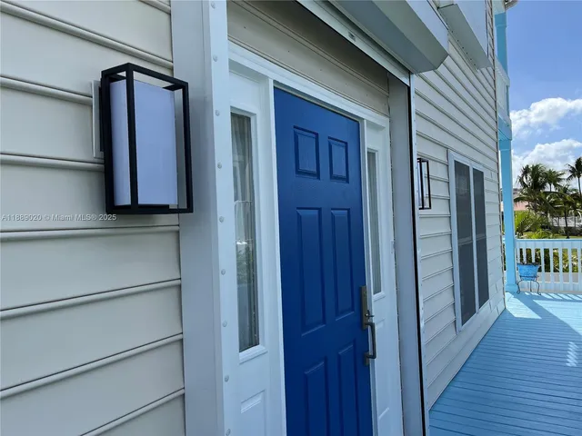 a view of a hallway with wooden floor and a door