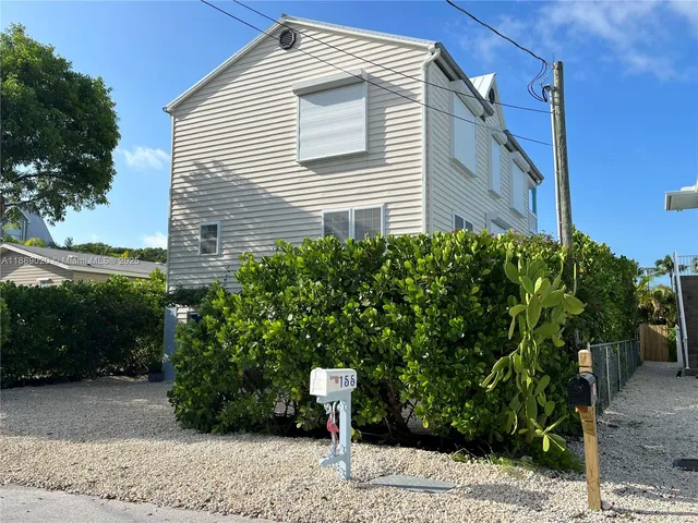 a view of a yard with plants and trees