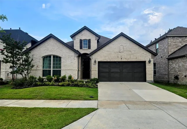 a front view of a house with a garden and yard