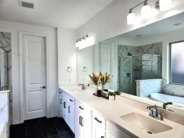 a bathroom with double vanity sinks and a mirror