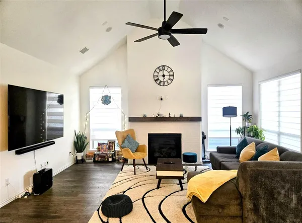 a living room with furniture a flat screen tv and a fireplace
