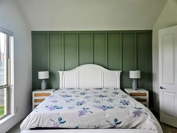 a large bed sitting in a bedroom next to a window and bathroom