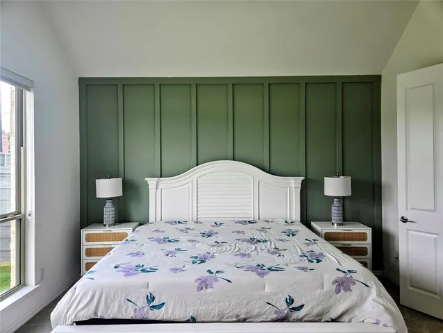 a large bed sitting in a bedroom next to a window and bathroom