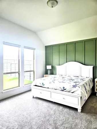 a large white bed sitting in a bedroom next to a window