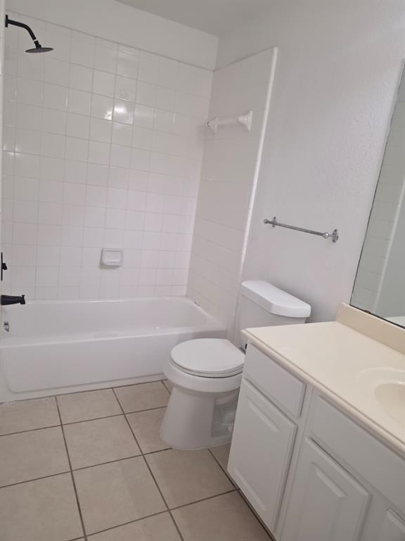 8047 New Kent Road Frisco, TX 75035 - Photo 22 of 27 Bathroom featuring a white subway-tiled tub and shower combination with a black shower head, a white toilet, a vanity with white cabinetry, a light-toned countertop, and a large mirror