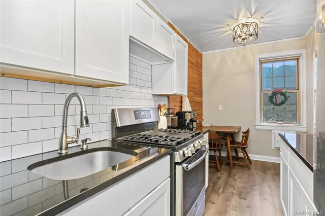 a kitchen with granite countertop a sink stove and cabinets