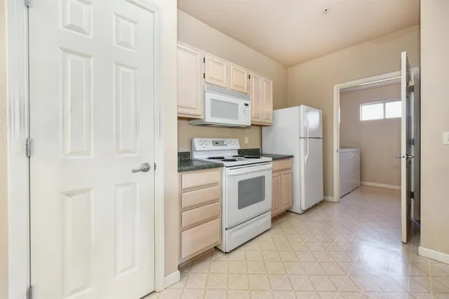 a kitchen with white cabinets and white appliances