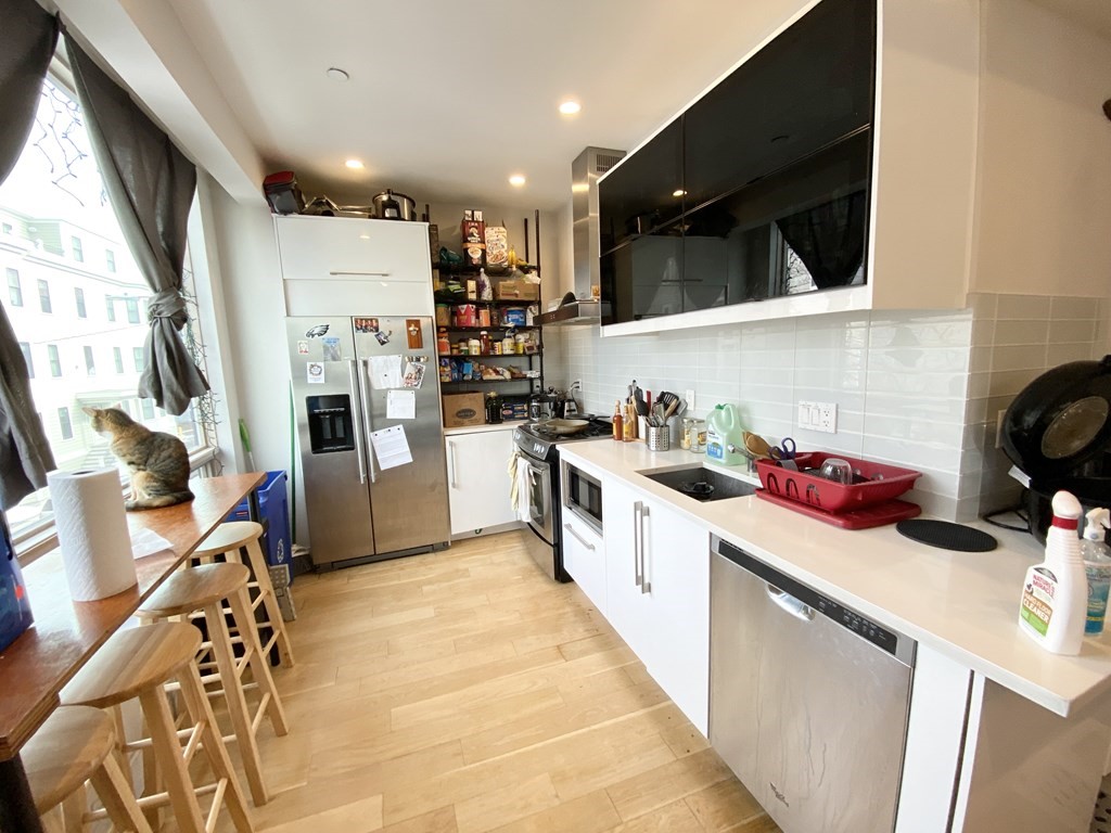 a kitchen with a sink a refrigerator and cabinets