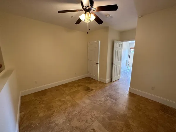 en empty room with ceiling fan and window