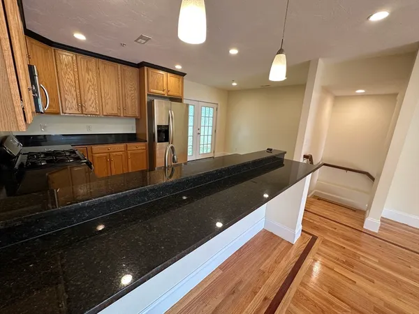 a kitchen with stainless steel appliances granite countertop a refrigerator and a sink
