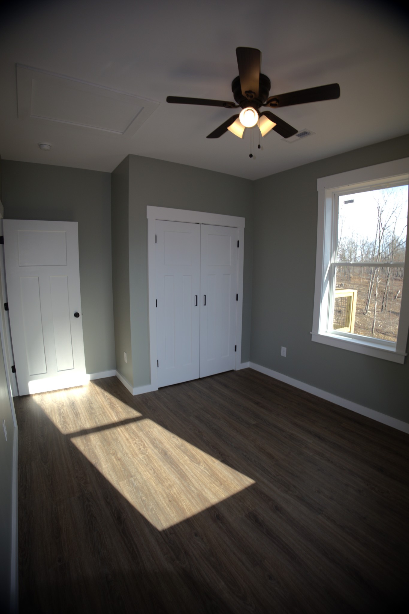 695 Woodland Road Hohenwald, TN 38462 - Photo 12 of 22 a view of an empty room and window and wooden floor