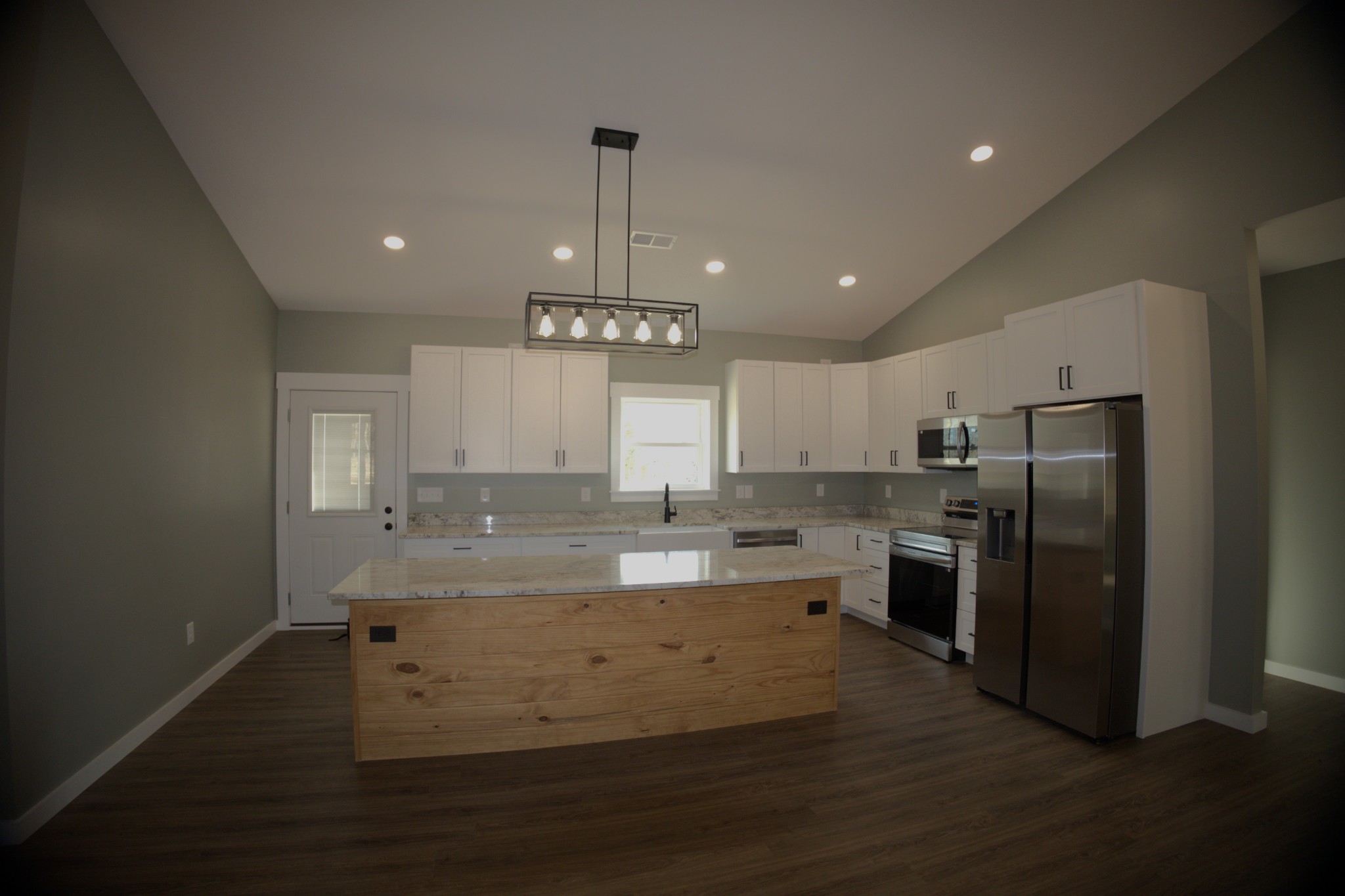 695 Woodland Road Hohenwald, TN 38462 - Photo 4 of 22 a view of a kitchen with stainless steel appliances granite countertop a sink and a refrigerator