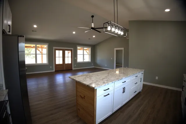 a kitchen with stainless steel appliances granite countertop a stove oven and a kitchen island
