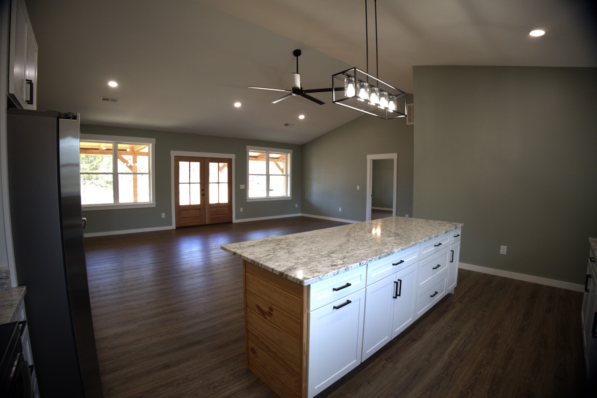 695 Woodland Road Hohenwald, TN 38462 - Photo 5 of 22 a spacious kitchen with a granite countertop sink and chandelier