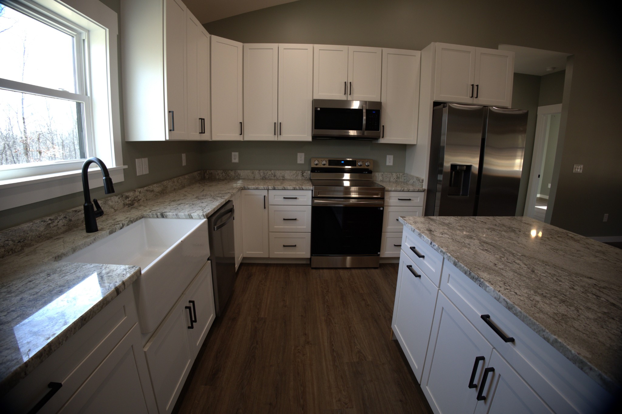 695 Woodland Road Hohenwald, TN 38462 - Photo 6 of 22 a kitchen with stainless steel appliances granite countertop a stove a sink and a refrigerator