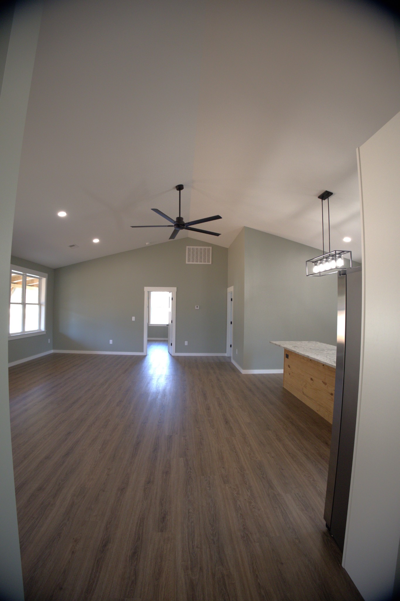 695 Woodland Road Hohenwald, TN 38462 - Photo 8 of 22 an empty room with wooden floor and windows