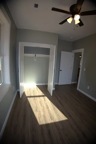 a view of an empty room and window and wooden floor