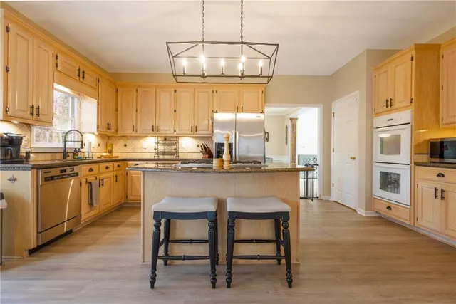 a kitchen with stainless steel appliances granite countertop a refrigerator sink and cabinets
