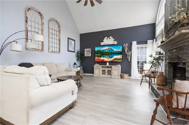 a living room with furniture a fireplace and a dining table with wooden floor