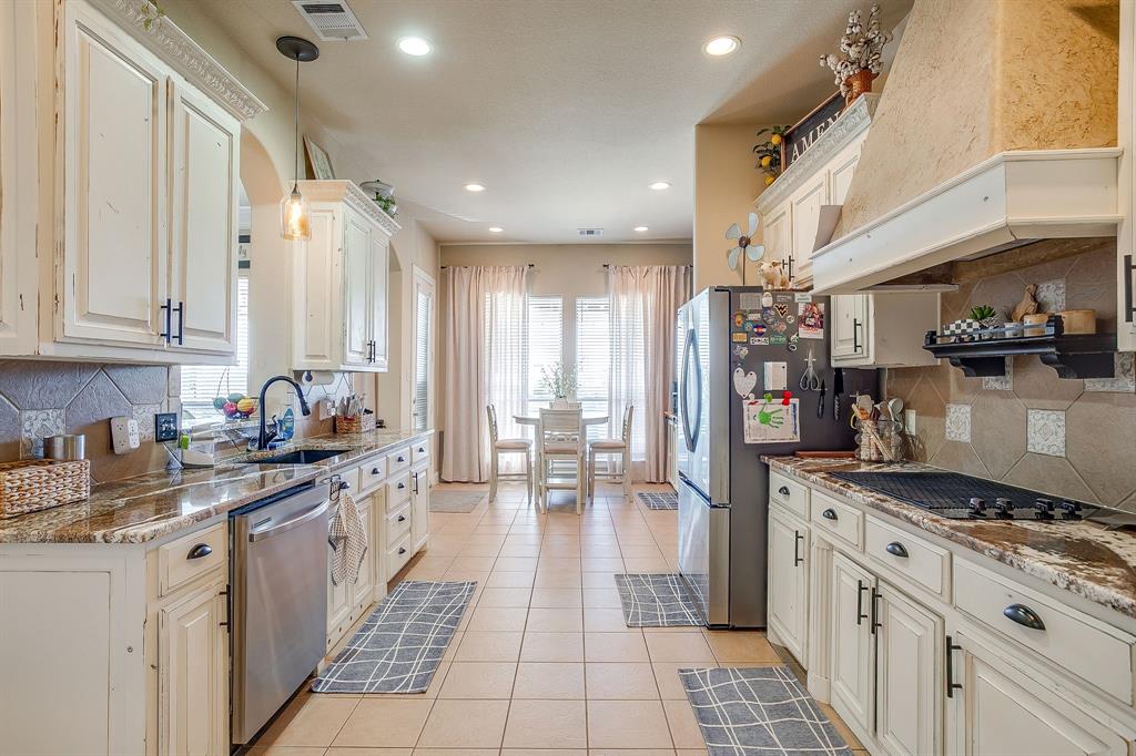 9409 County Road 915 Godley, TX 76044 - Photo 12 of 40 a kitchen with stainless steel appliances granite countertop a stove and a refrigerator