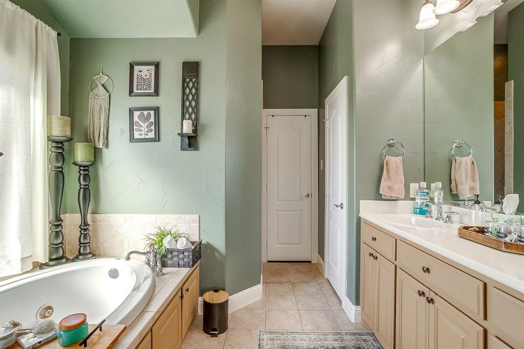 9409 County Road 915 Godley, TX 76044 - Photo 19 of 40 a bathroom with a tub sink and mirror
