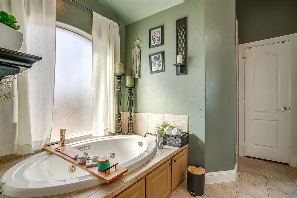9409 County Road 915 Godley, TX 76044 - Photo 20 of 40 a bath tub sitting next to a white sink and a window