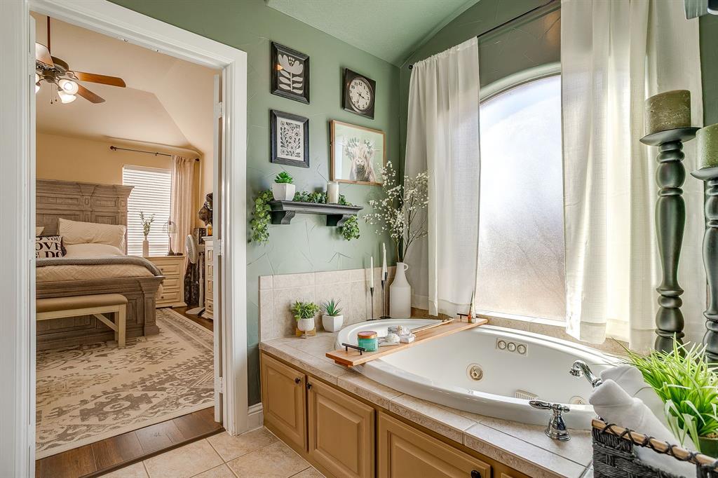 9409 County Road 915 Godley, TX 76044 - Photo 22 of 40 a bathroom with a tub sink and mirror