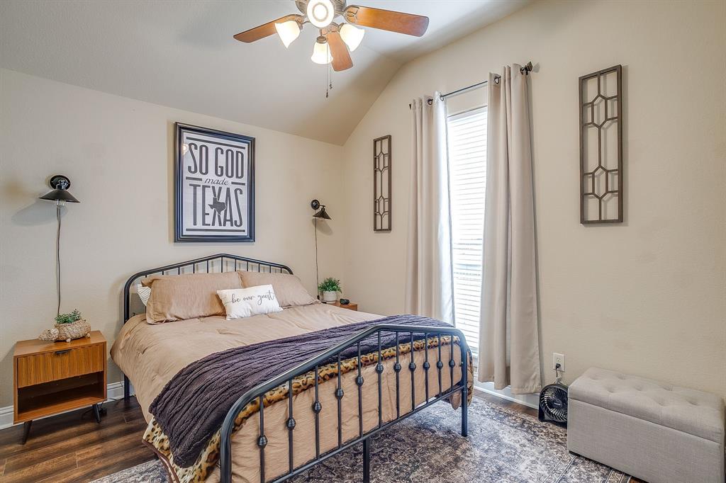 9409 County Road 915 Godley, TX 76044 - Photo 25 of 40 a bedroom with a bed and a chandelier