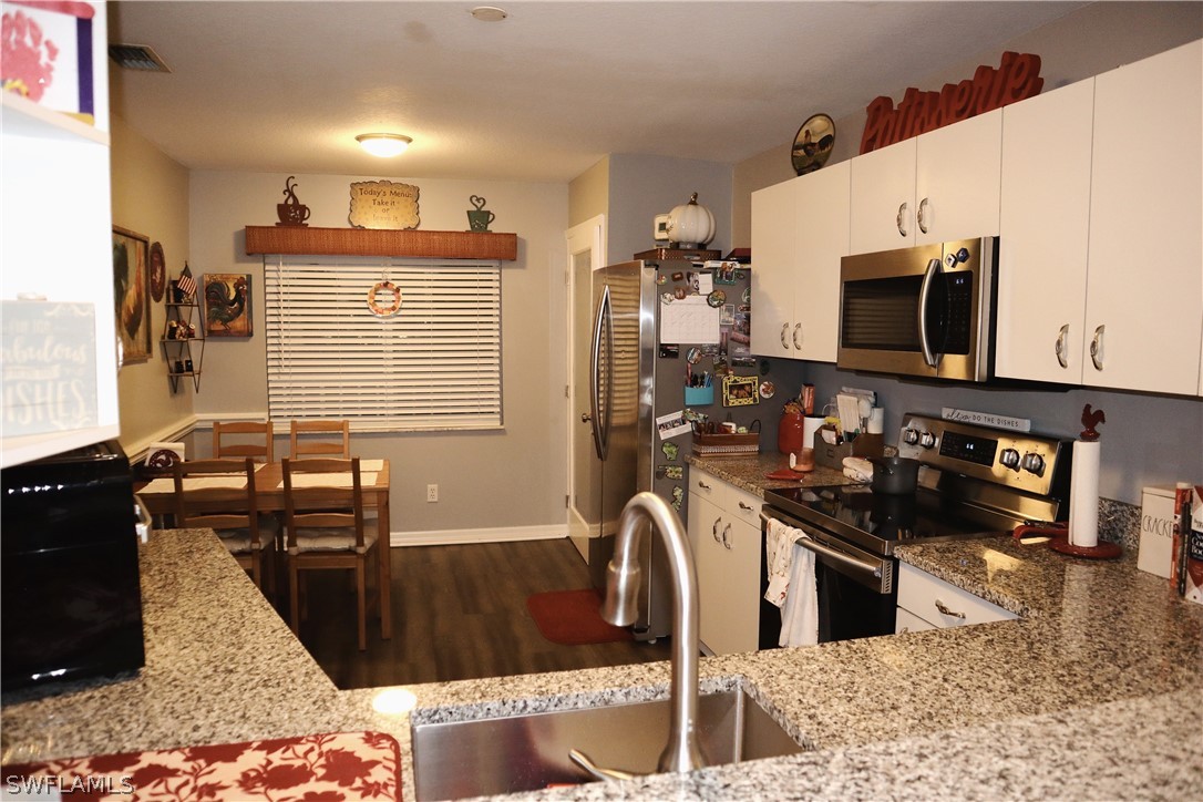 a kitchen with stainless steel appliances kitchen island granite countertop a stove a sink and a microwave