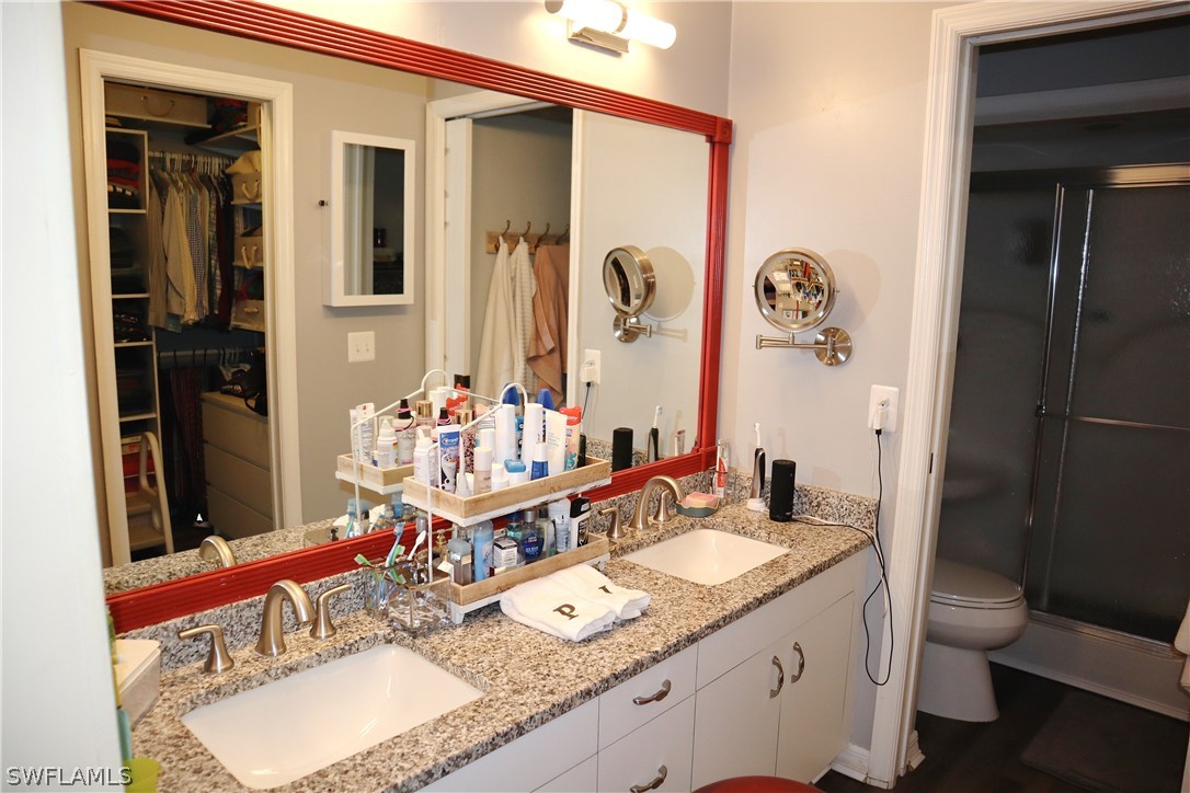 121 Gabriel Circle, Unit 10 Naples, FL 34104 - Photo 14 of 25 a bathroom with a granite countertop sink and a mirror
