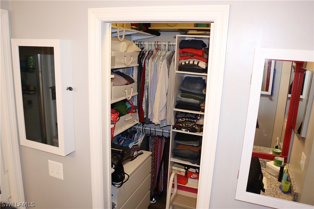 121 Gabriel Circle, Unit 10 Naples, FL 34104 - Photo 16 of 25 a view of walk in closet with clothes and shoes