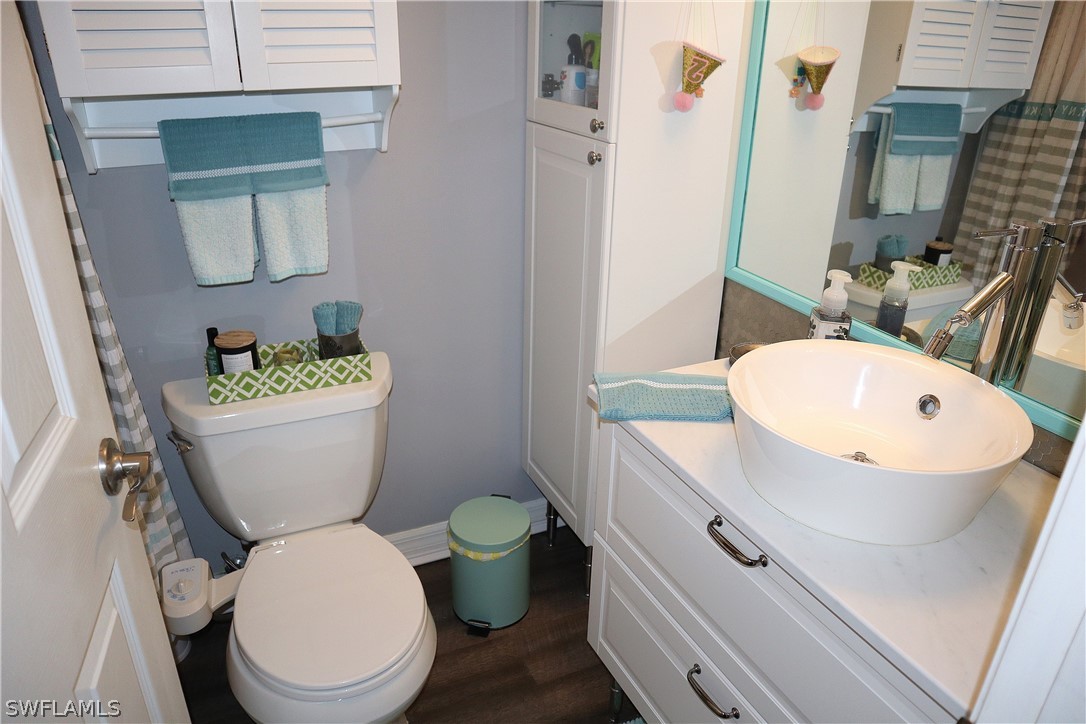 121 Gabriel Circle, Unit 10 Naples, FL 34104 - Photo 20 of 25 a white toilet sitting next to a bathroom sink
