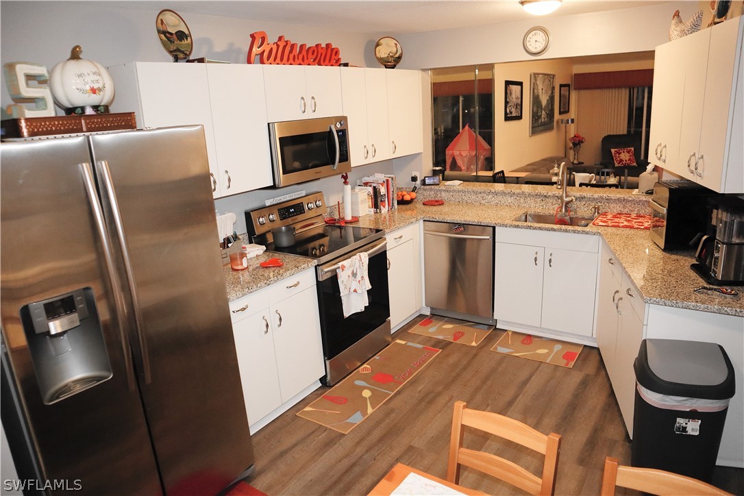 121 Gabriel Circle, Unit 10 Naples, FL 34104 - Photo 2 of 25 a kitchen with stainless steel appliances a stove refrigerator sink and a microwave
