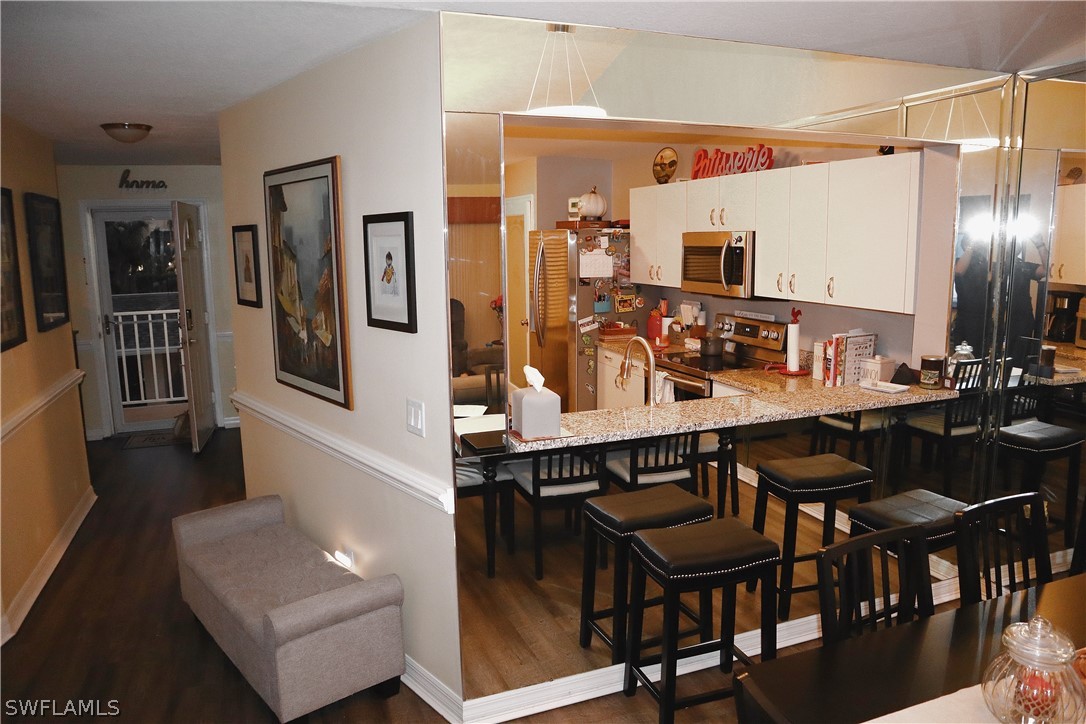 121 Gabriel Circle, Unit 10 Naples, FL 34104 - Photo 3 of 25 a view of a dining room with furniture and wooden floor