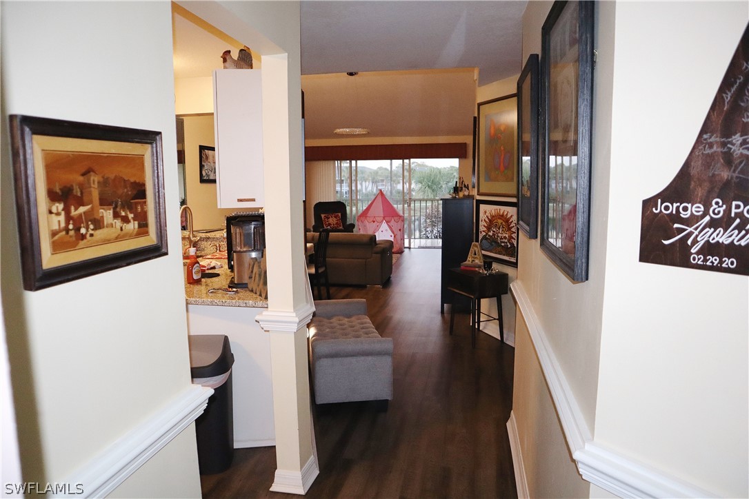 121 Gabriel Circle, Unit 10 Naples, FL 34104 - Photo 6 of 25 a view of a hallway with furniture and wooden floor