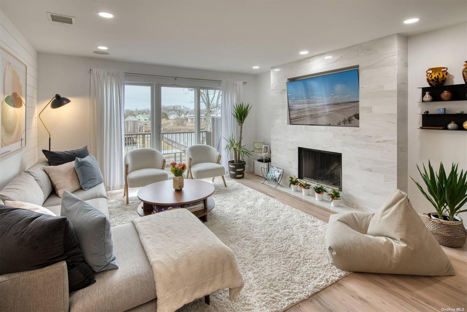 3029 Mitchell Road Westhampton Beach, NY 11978 - Photo 3 of 12 a living room with furniture and a fireplace