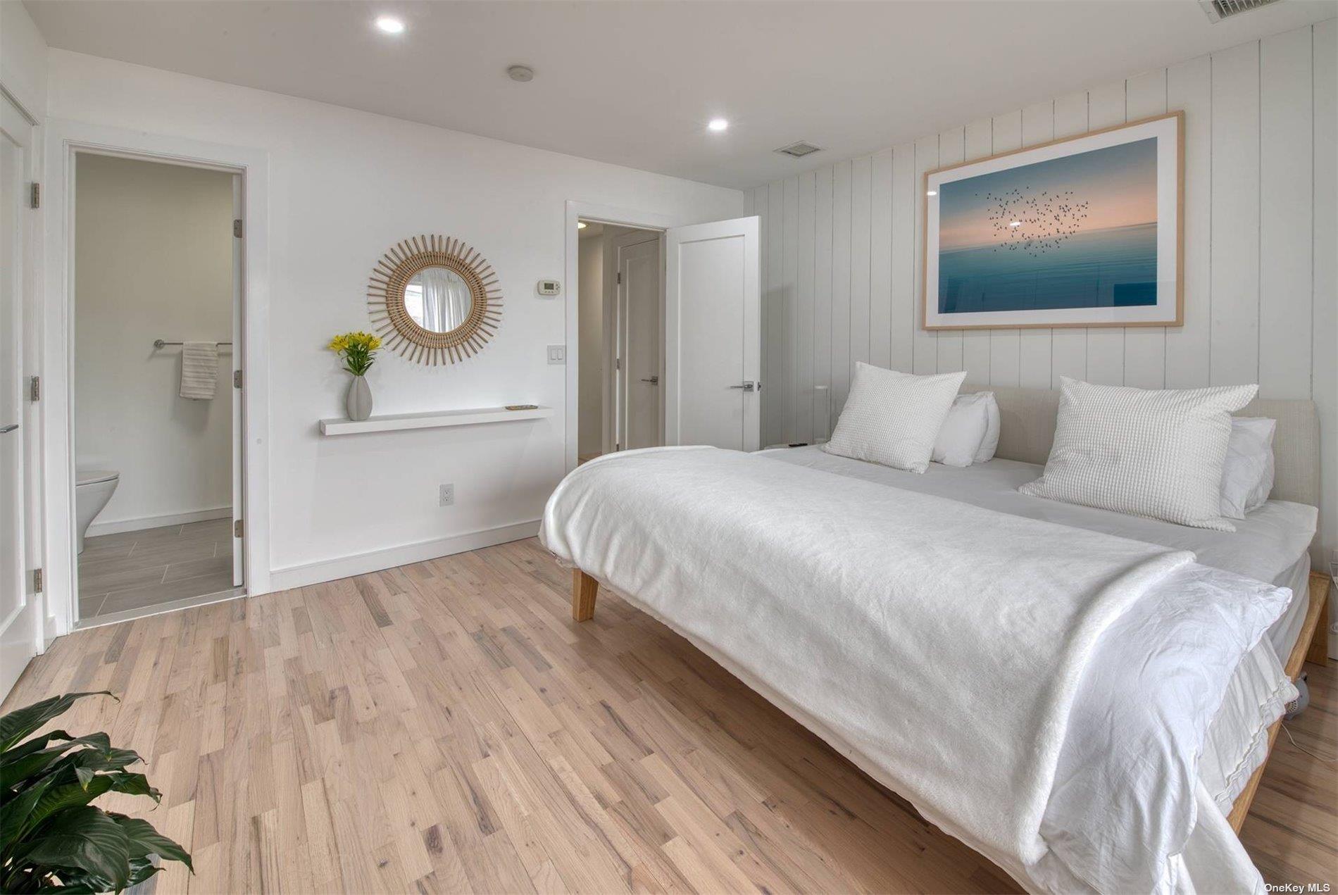 3029 Mitchell Road Westhampton Beach, NY 11978 - Photo 6 of 12 a bedroom with a bed and a mirror