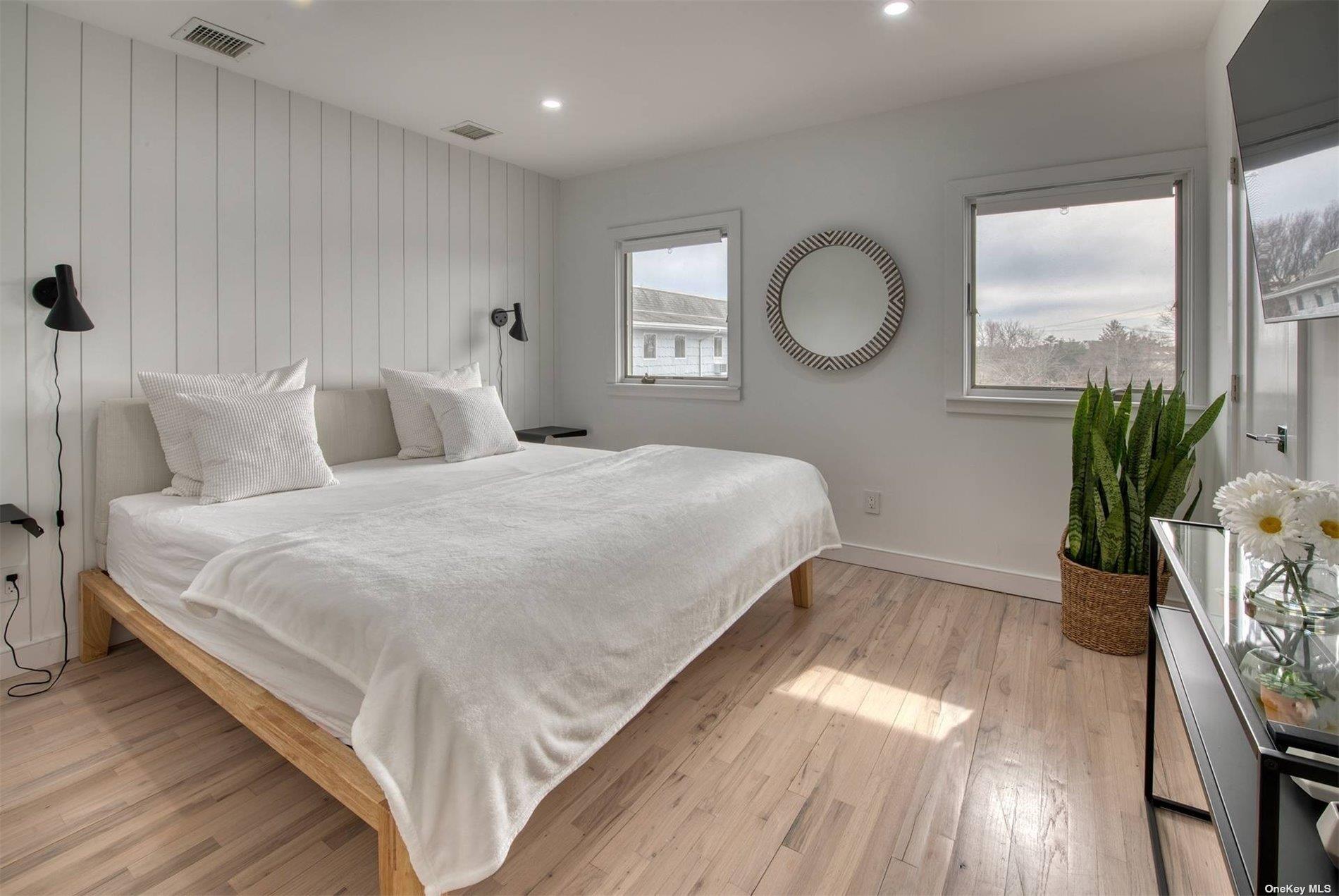 3029 Mitchell Road Westhampton Beach, NY 11978 - Photo 7 of 12 a bedroom with a bed and a potted plant