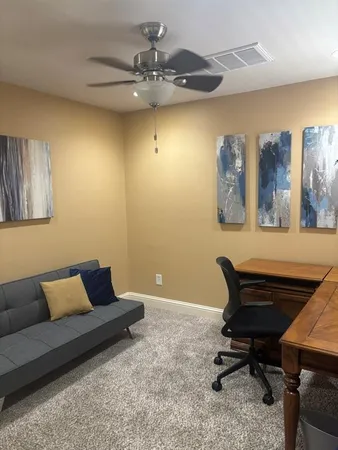 a view of a workspace with furniture and a window